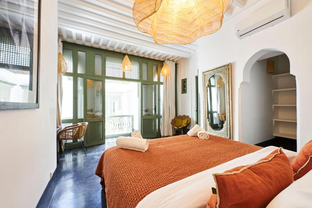 a bedroom with a large bed and a large window at Riad Dar Nakous in Marrakesh