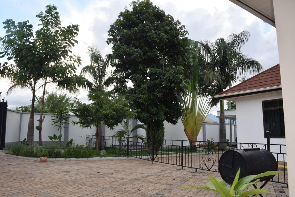 una recinzione di fronte a una casa con un albero di Two Bedrooms Apartment Moshi a Bunju