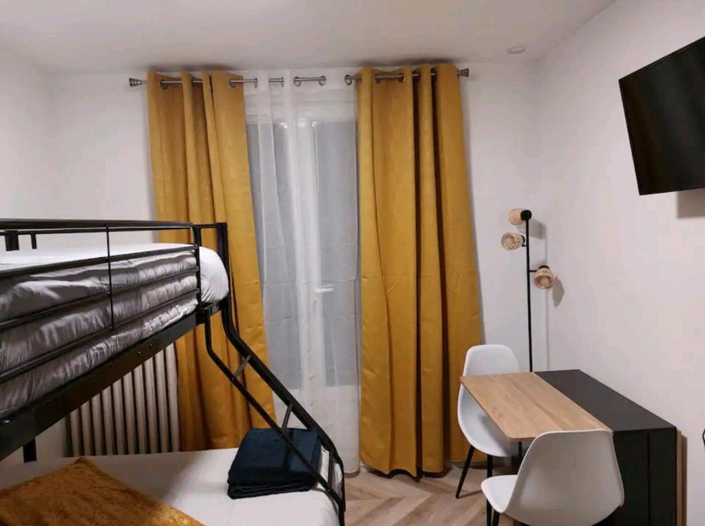 Monastère في فيل ديفرايْ: غرفة مع سرير بطابقين ومكتب وطاولة