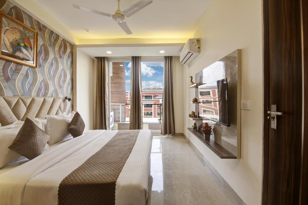 a bedroom with a large bed and a large window at Limewood Stay Golf Course Road in Gurgaon