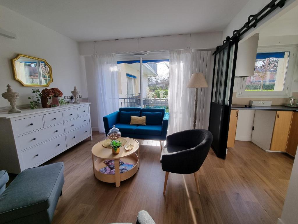 ein Wohnzimmer mit einem blauen Sofa und einem Tisch in der Unterkunft La Rose in Croissy-sur-Seine