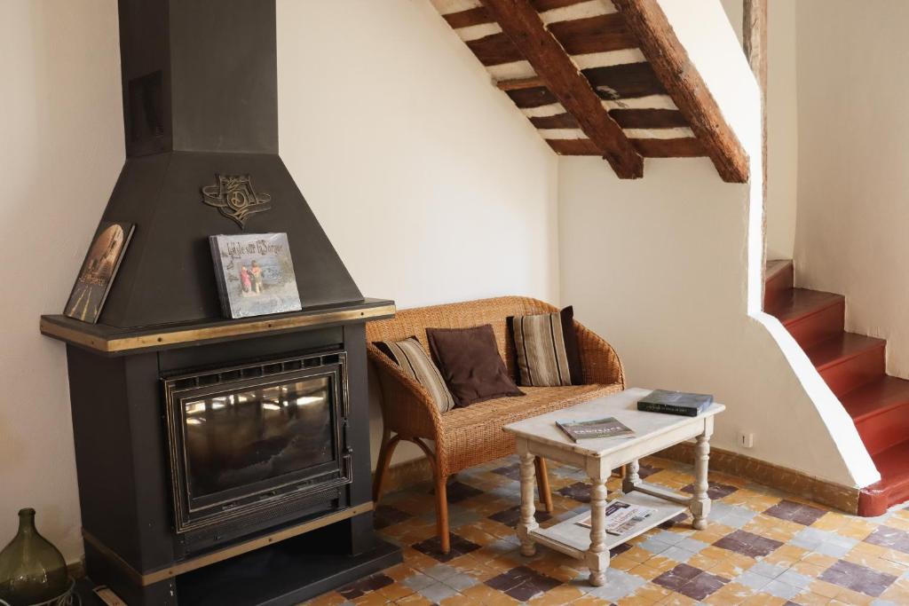 uma sala de estar com lareira e sofá em Gîte de l'Escanson un temps pour soi em Robion en Luberon