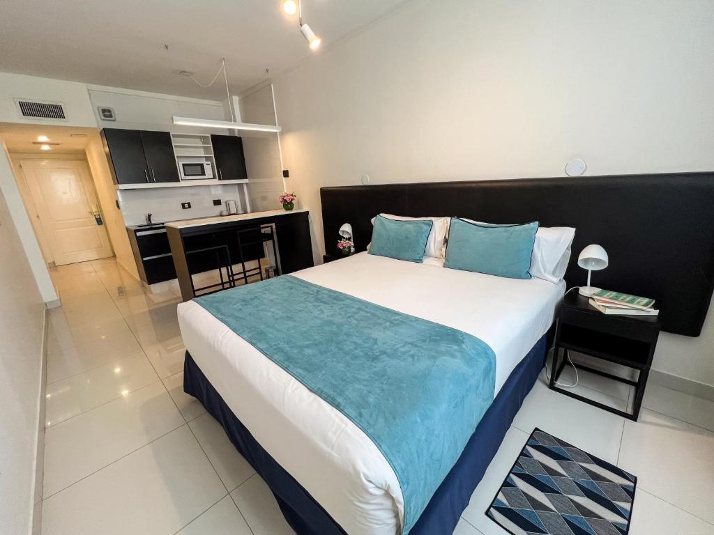 1 Schlafzimmer mit einem großen Bett und einer Küche in der Unterkunft Cyan Recoleta Hotel in Buenos Aires