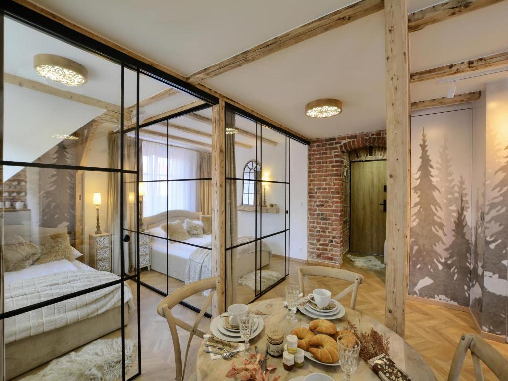 a room with a table and a bed and glass walls at CENTRUM 47 KARPACZ in Karpacz