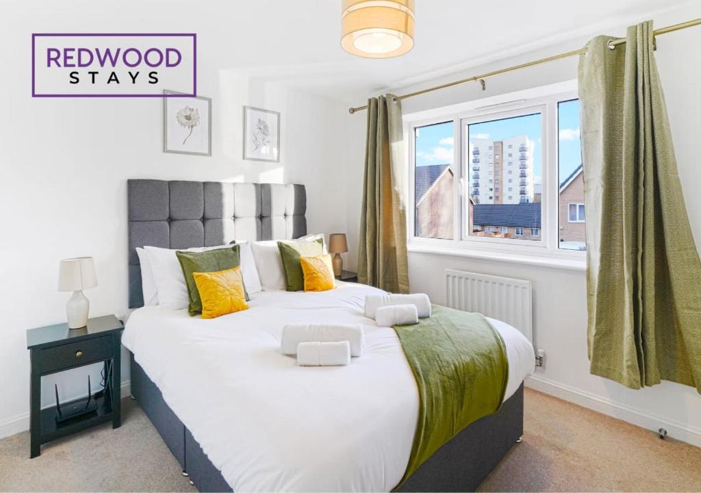 a bedroom with a large bed and a window at BRAND NEW! 3 Bed 2 Bath House, NEAR HOSPITAL, With FREE x2 Parking & Wi-Fi By REDWOOD STAYS in Basingstoke