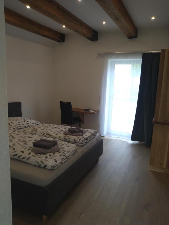 1 dormitorio con cama, ventana y escritorio en Weingut Brandl, en Strass