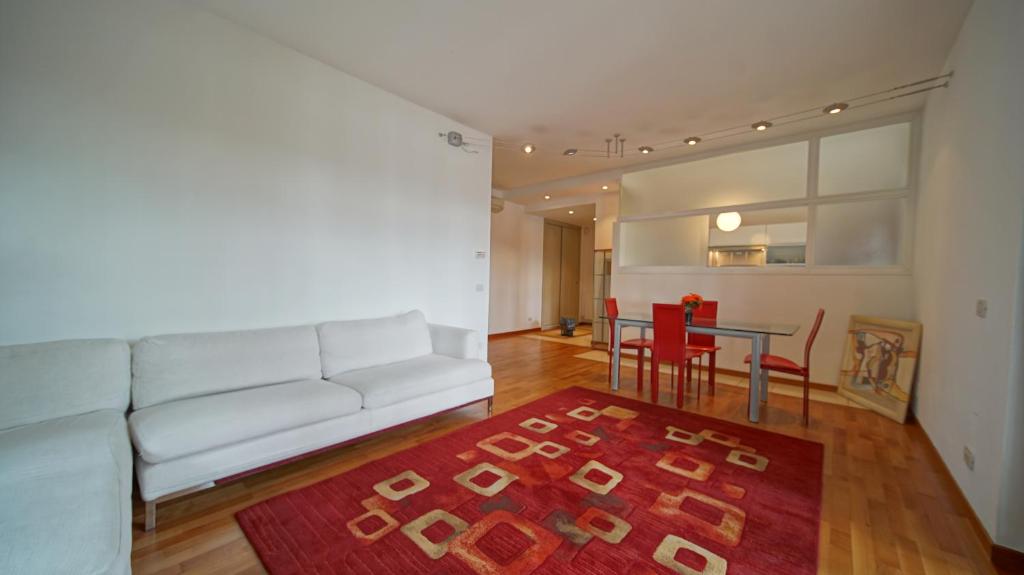ein Wohnzimmer mit einem weißen Sofa und einem Tisch in der Unterkunft Destiny home 9 vista adige in Verona