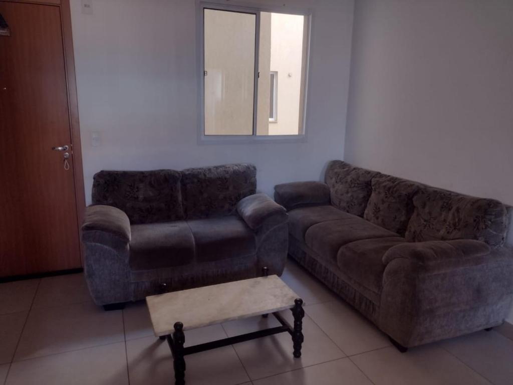 ein Wohnzimmer mit einem Sofa und einem Stuhl in der Unterkunft Manacá in Ribeirão Preto