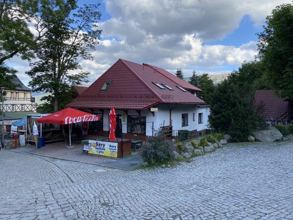 a building with a red roof and a coca cola sign at Dom przy Wangu Karpacz in Karpacz