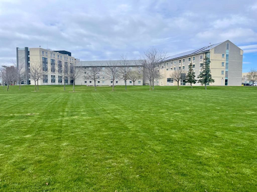 a large grass field in front of a building at Residence & Conference Centre - Kingston in Kingston