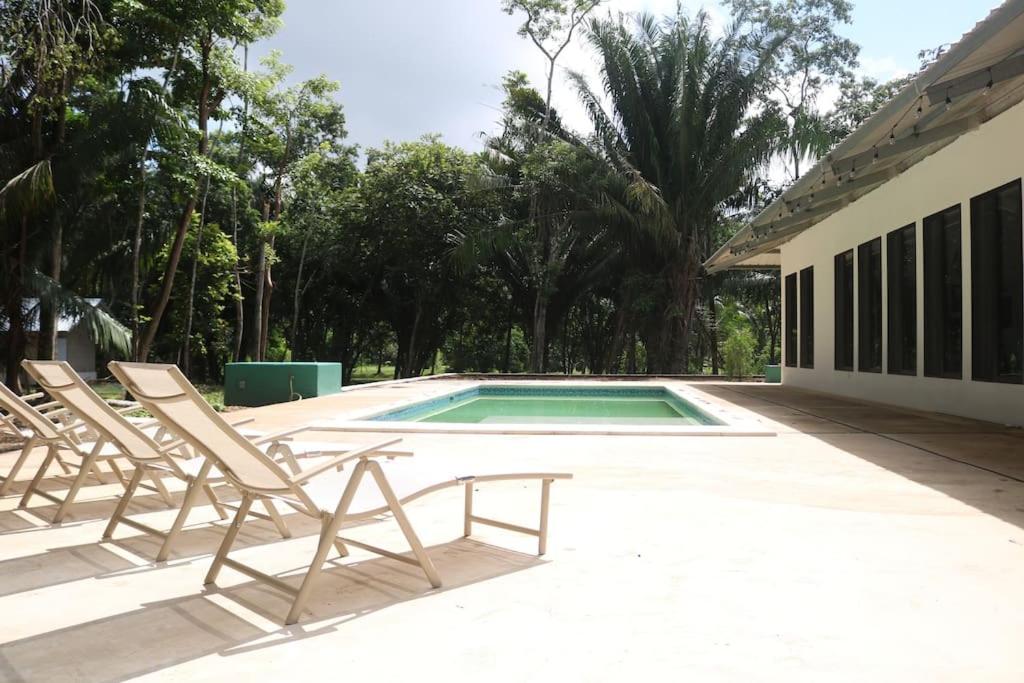 a group of chairs sitting next to a swimming pool at Central Oasis Private Pool BBQ in Belmopan