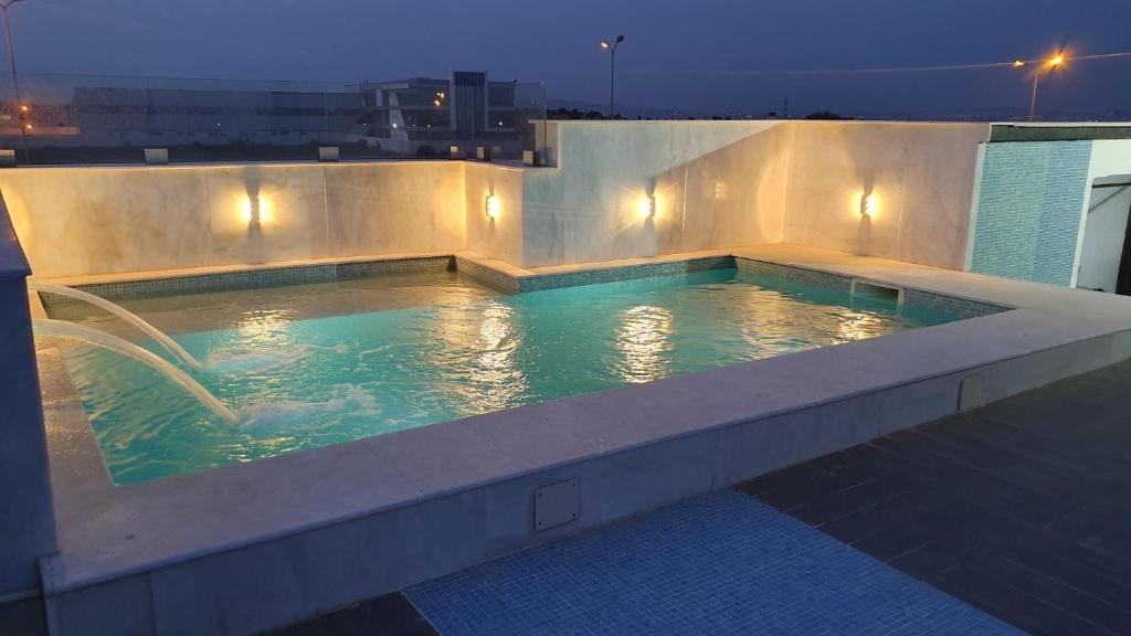 - une piscine au-dessus d'un bâtiment la nuit dans l'établissement Merveilleuse villa luxe privée, à Tunis