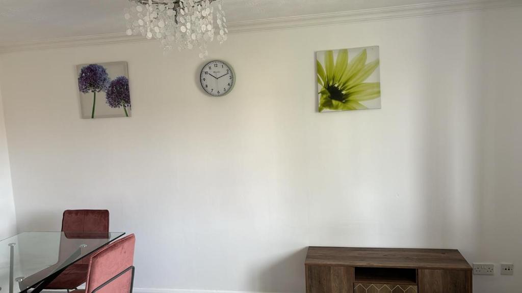 a white wall with three pictures and a clock on it at Centre reache in Southend-on-Sea
