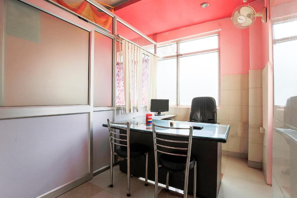 a room with a desk with chairs and a window at OYO Flagship 37109 Mangalam Guest House in Chinhat