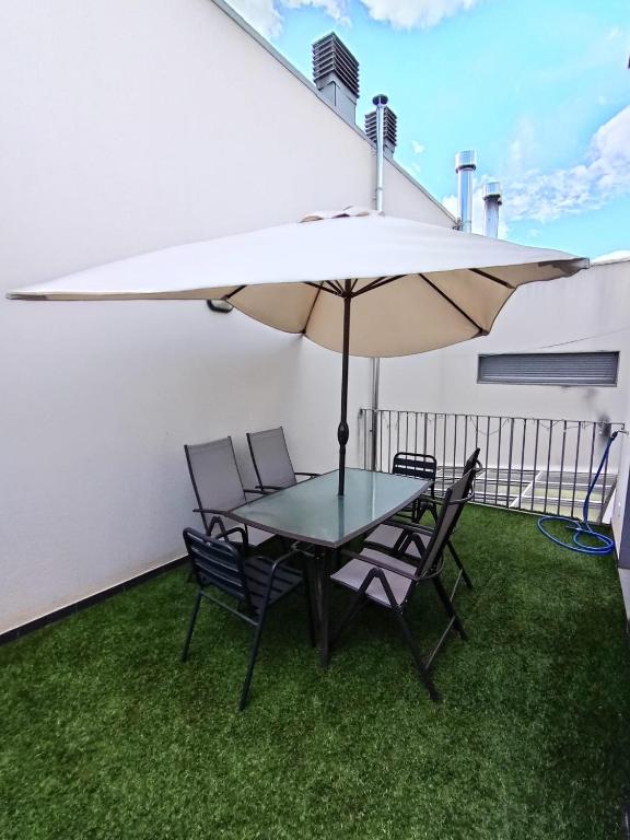 a patio with a table and chairs and an umbrella at Duplex GABY in Sabiñánigo