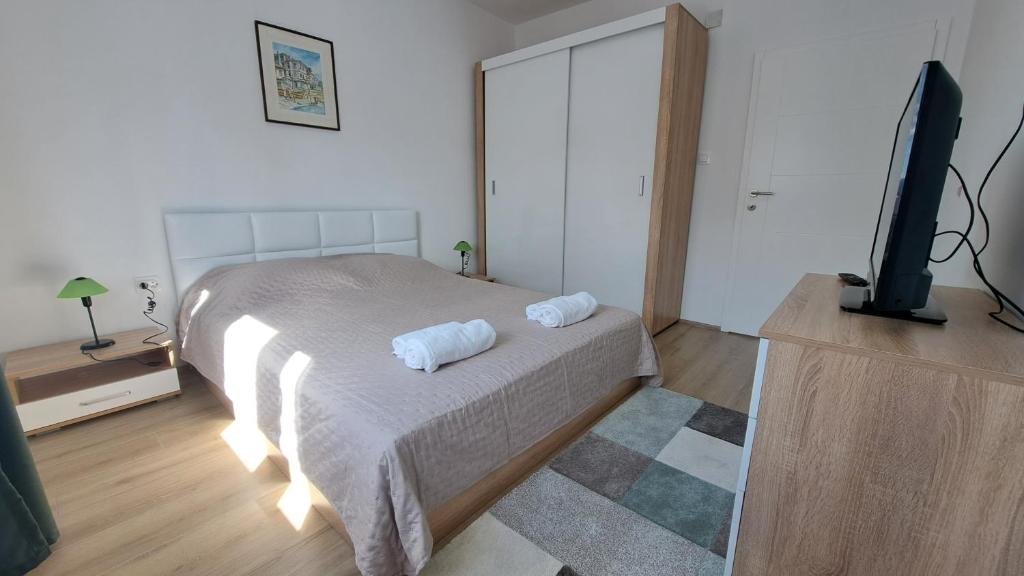 a bedroom with a bed and a flat screen tv at Vera City Square Apartment in Skopje