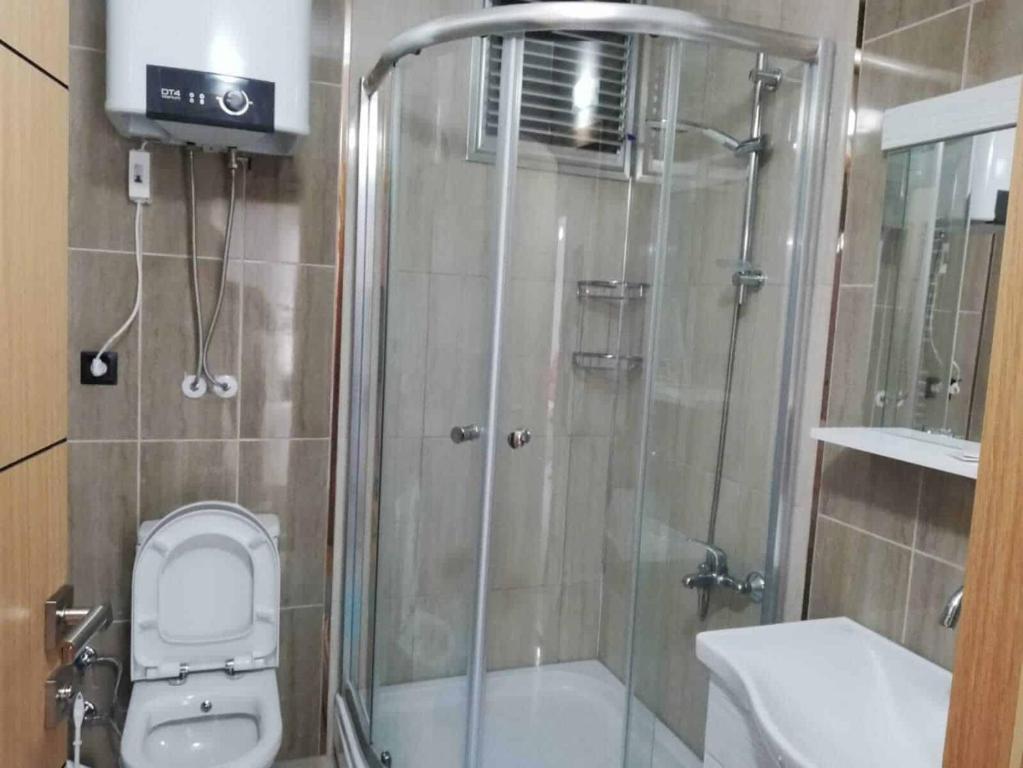 a bathroom with a shower with a toilet and a sink at at-Tafilah Ross inn in Tufailah