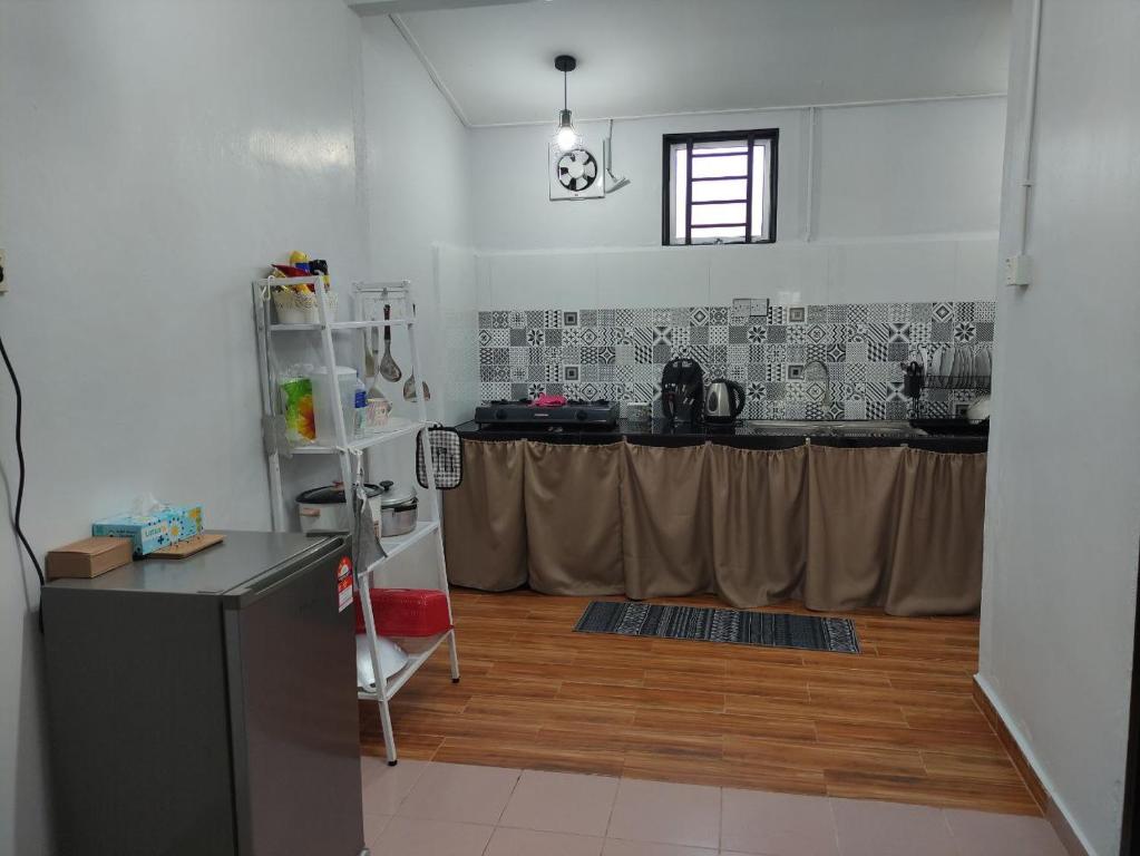 cocina con encimera y mesa en una habitación en Maileyna Homestay 1.0, en Alor Setar