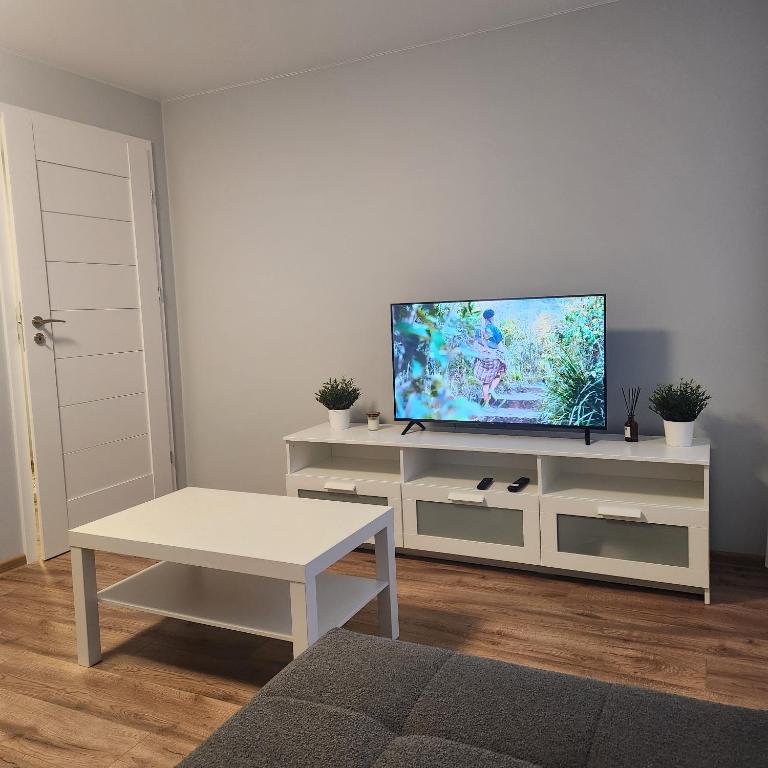 una sala de estar con TV de pantalla plana en un armario blanco en Butas Sedos gatvėje, en Telšiai