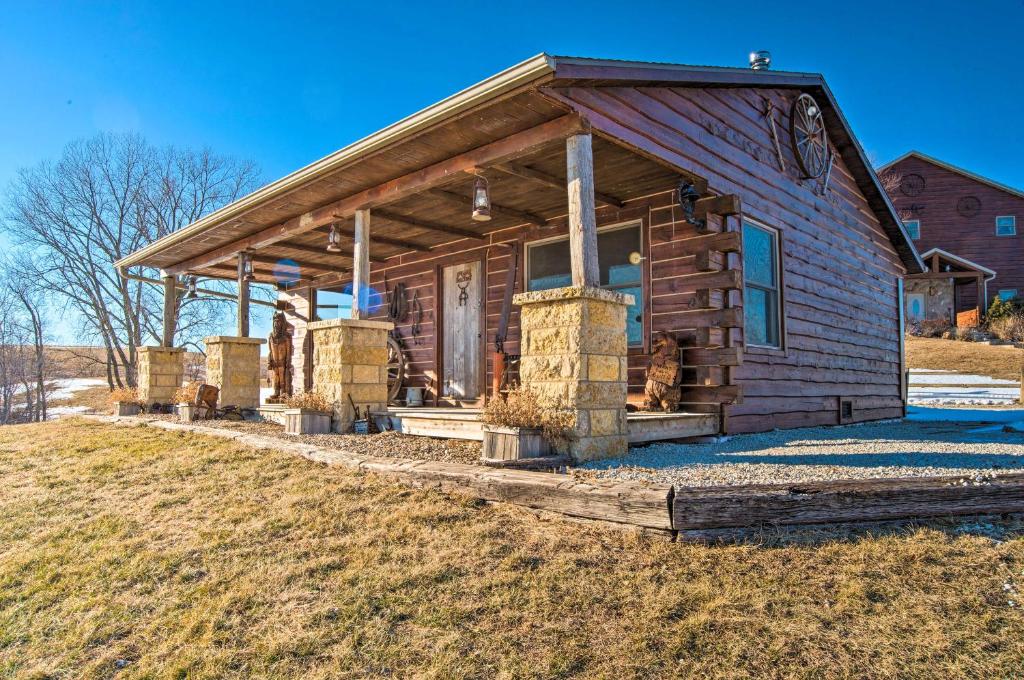 een blokhut met een veranda op een veld bij Secluded Powersville Cabin 25 Mi to Lake Paho! 