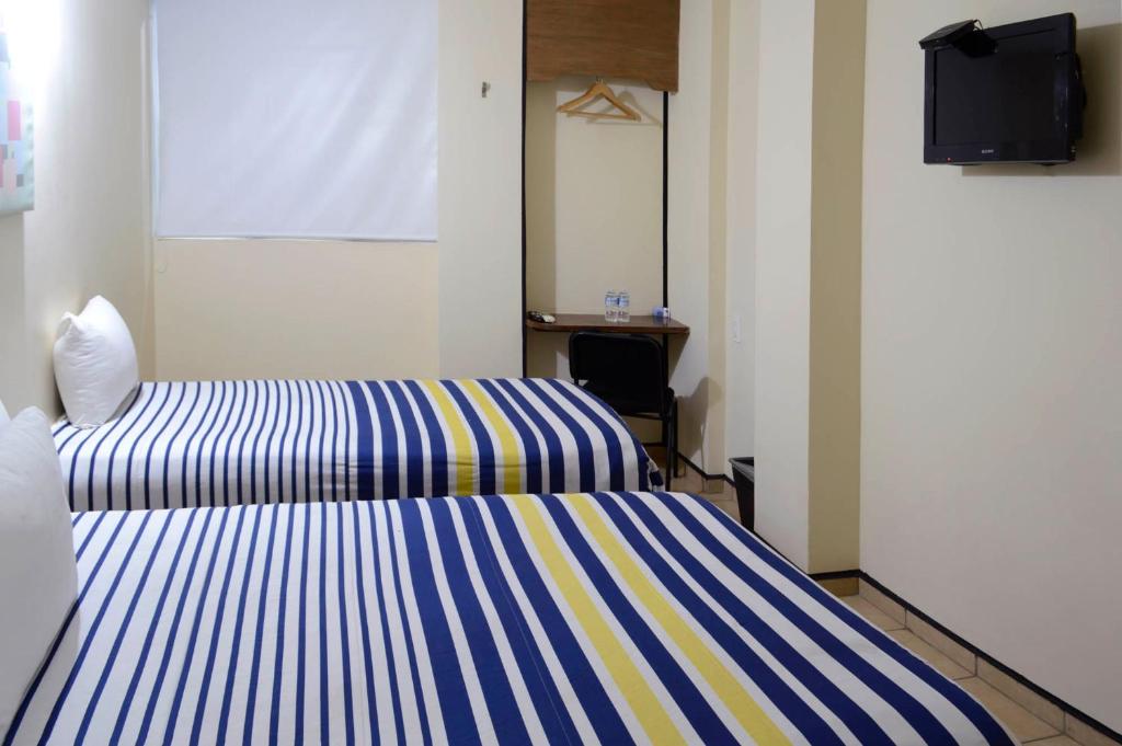 Postel nebo postele na pokoji v ubytování Hotel Mateos 1215