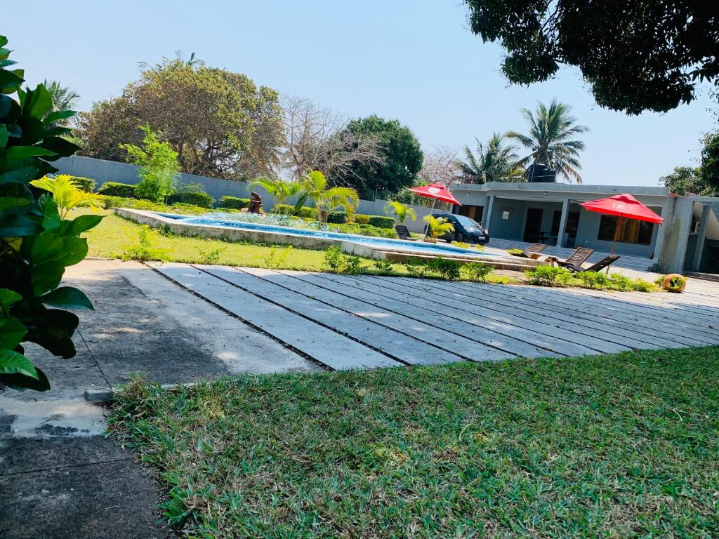 un jardin avec une table et des chaises ainsi qu'une maison dans l'établissement Ká Jackson Bilene, à Vila Praia Do Bilene