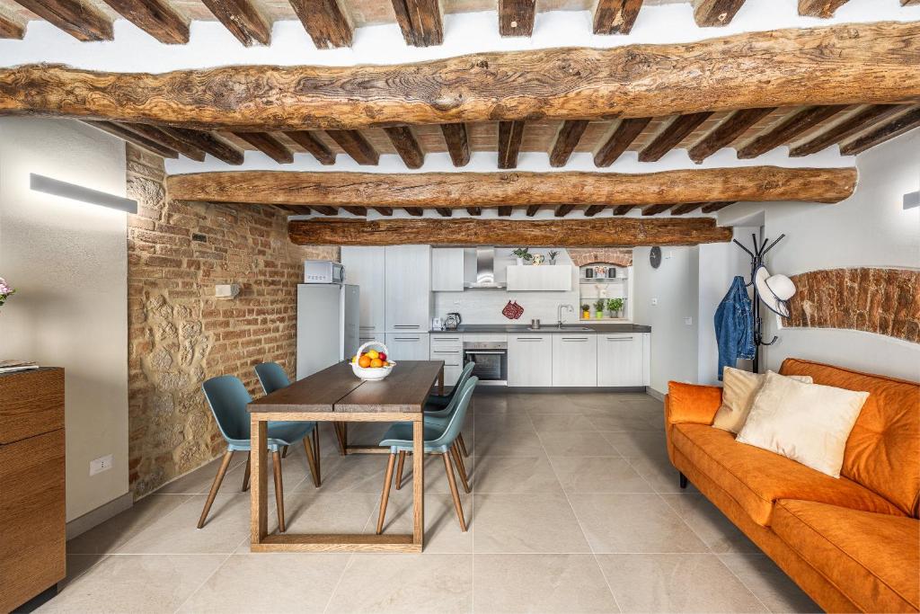ein Wohnzimmer mit einem Tisch und einem Sofa in der Unterkunft Il Mezzanino in Siena
