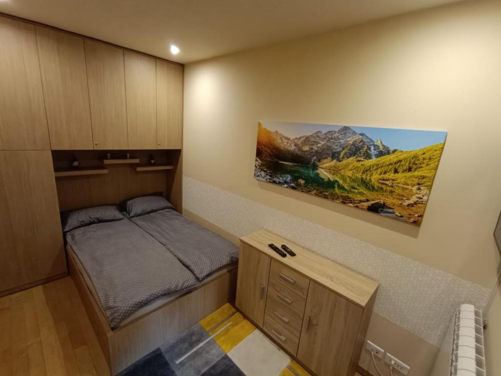 a small bedroom with a bed and a painting on the wall at ToTi Kalman in Zlatibor