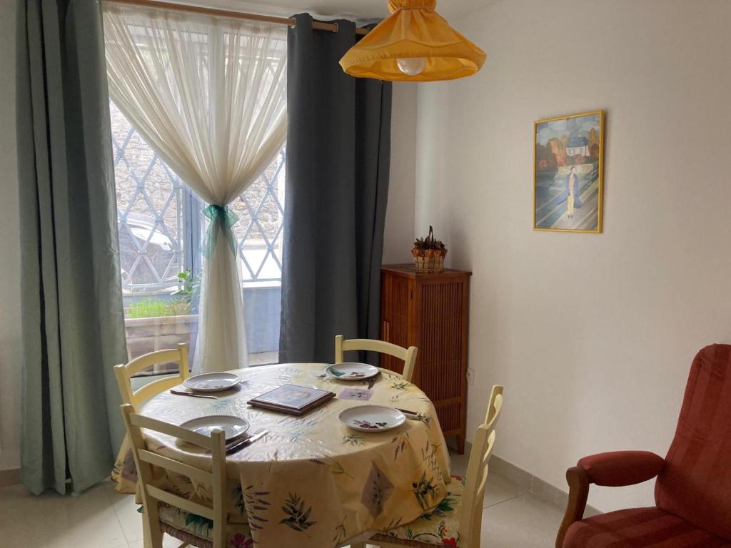 un tavolo da pranzo con sedie e una finestra di Studio RDC 35m2 Plein centre a Foix