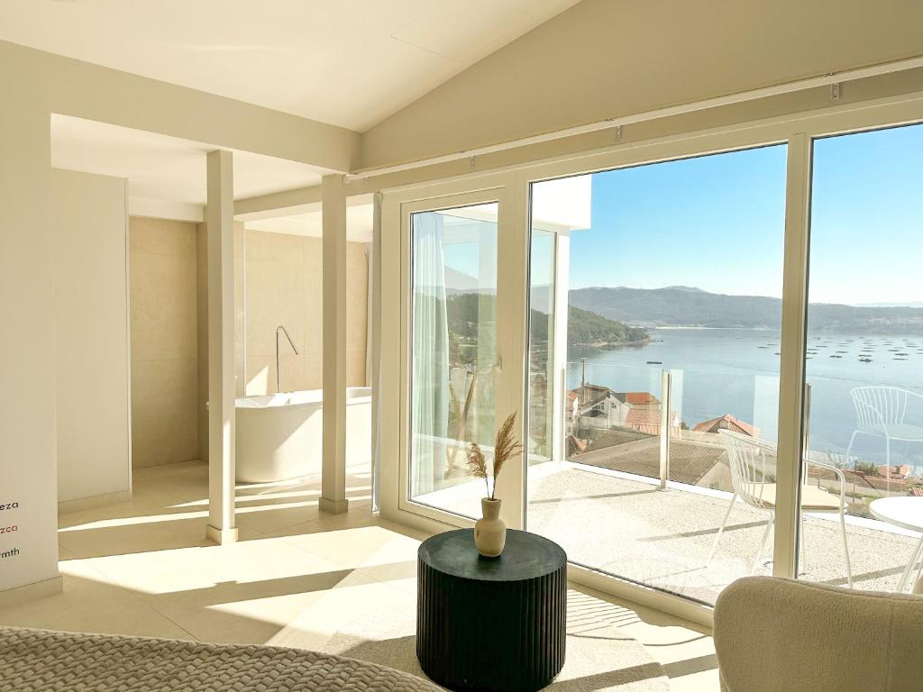 a living room with a view of the ocean at Otantus Hotel in Muros