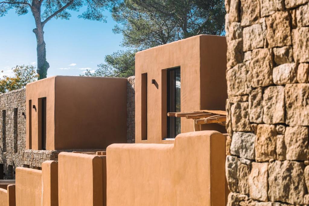 ein Haus in der Wüste mit einer Steinmauer in der Unterkunft Na Xamena in La Croix-Valmer