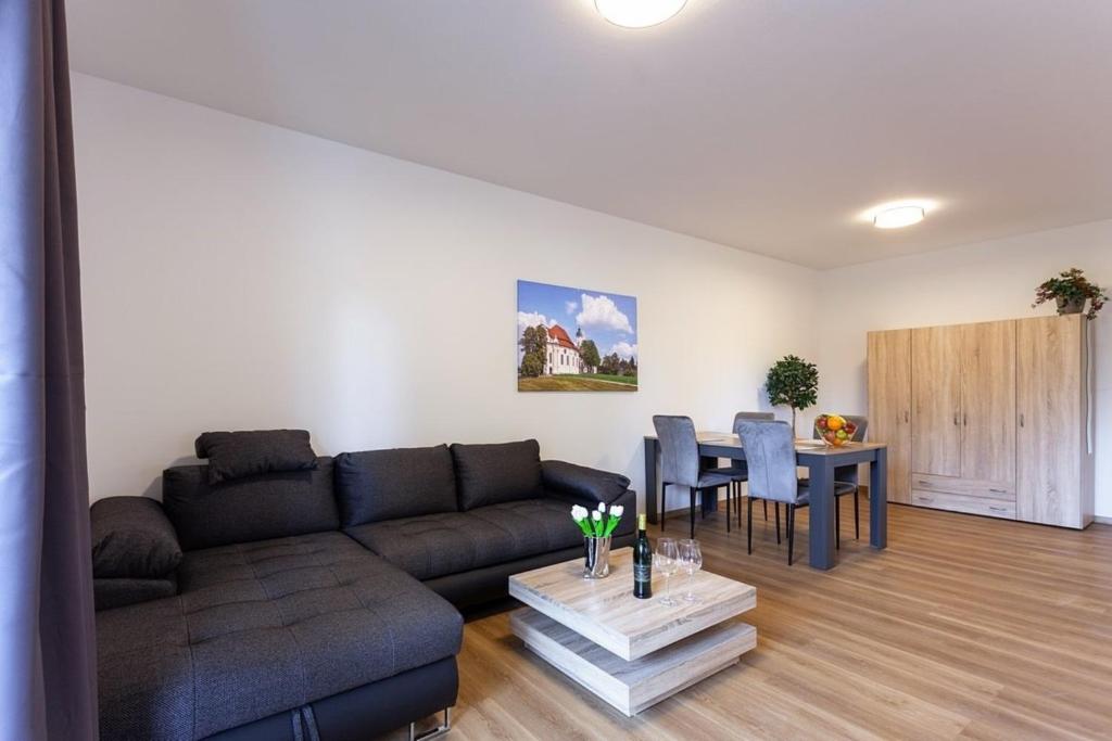 uma sala de estar com um sofá e uma mesa em Ferienwohnung 1 - b64402 em Lechbruck