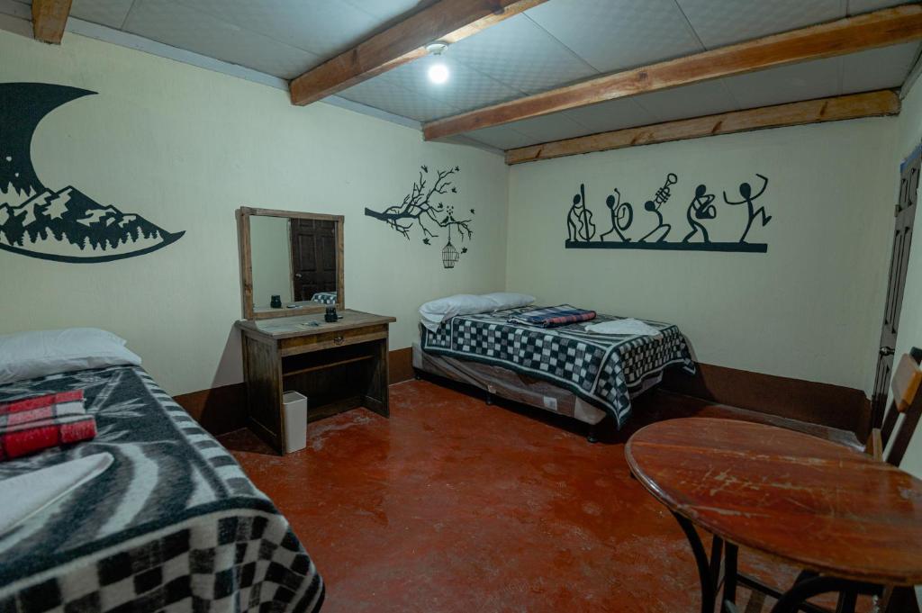 una camera con due letti, un tavolo e uno specchio di Salvaxia a Chichicastenango