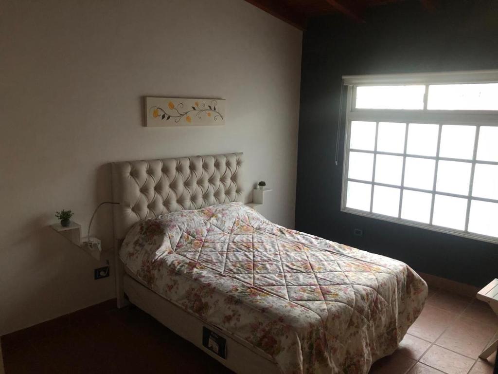 1 dormitorio con cama con edredón y ventana en Alquiler por Día Alca!!!! en Viedma