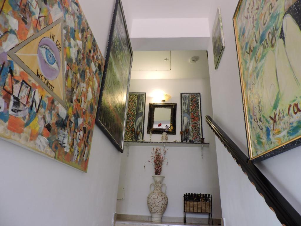 a hallway with paintings on the walls and a staircase at Four Season Apartament in Valea Adîncă