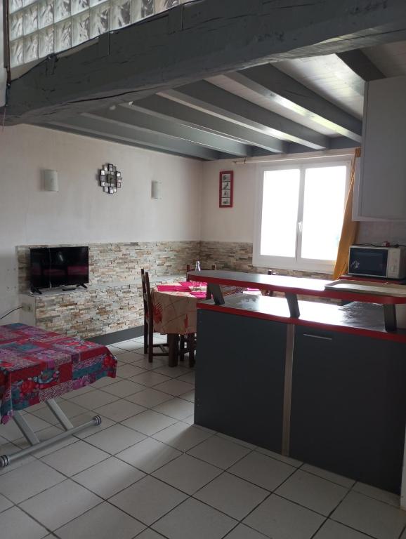 un salon avec une table et une cheminée dans l'établissement Appartement, à Saint-Pandelon