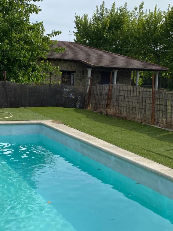 a blue swimming pool in front of a house at Los 11 Postes in Candeleda