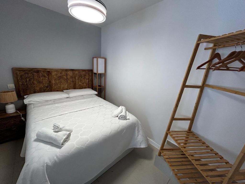 1 dormitorio con 1 cama con 2 toallas y 1 escalera en Casa Eliseo en Los Yébenes