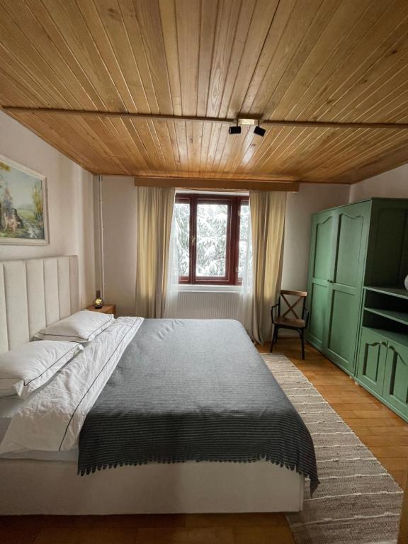 a bedroom with a large bed and a wooden ceiling at Paltin Evergreen Garana in Gărâna