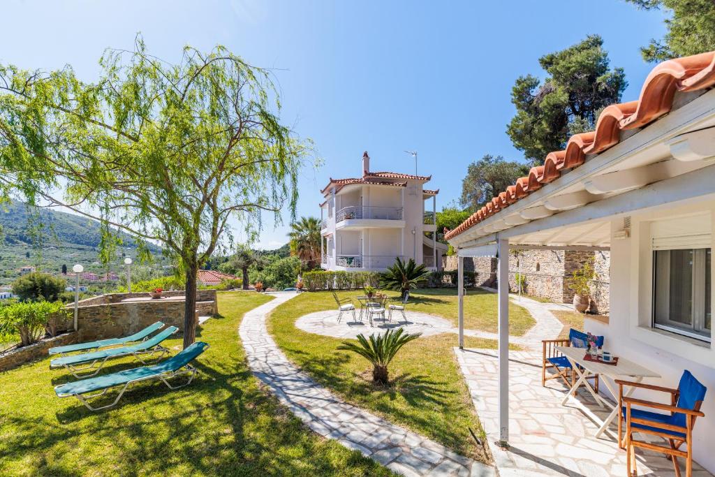 una casa con cortile, sedie e patio di Likasti a Skopelos Town