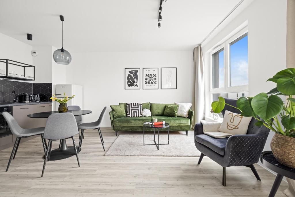 a living room with a green couch and a table at Serenity - Praia Apartments - Polsat Plus Arena Gdańsk in Gdańsk