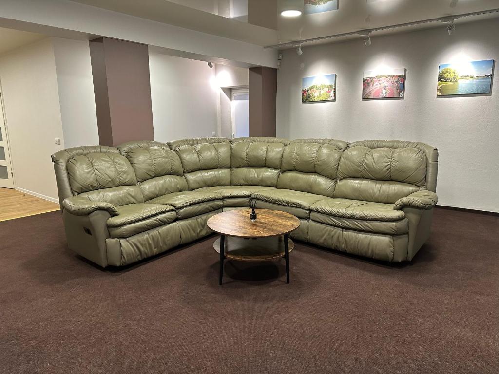 a leather couch in a room with a table at Živelina in Telšiai