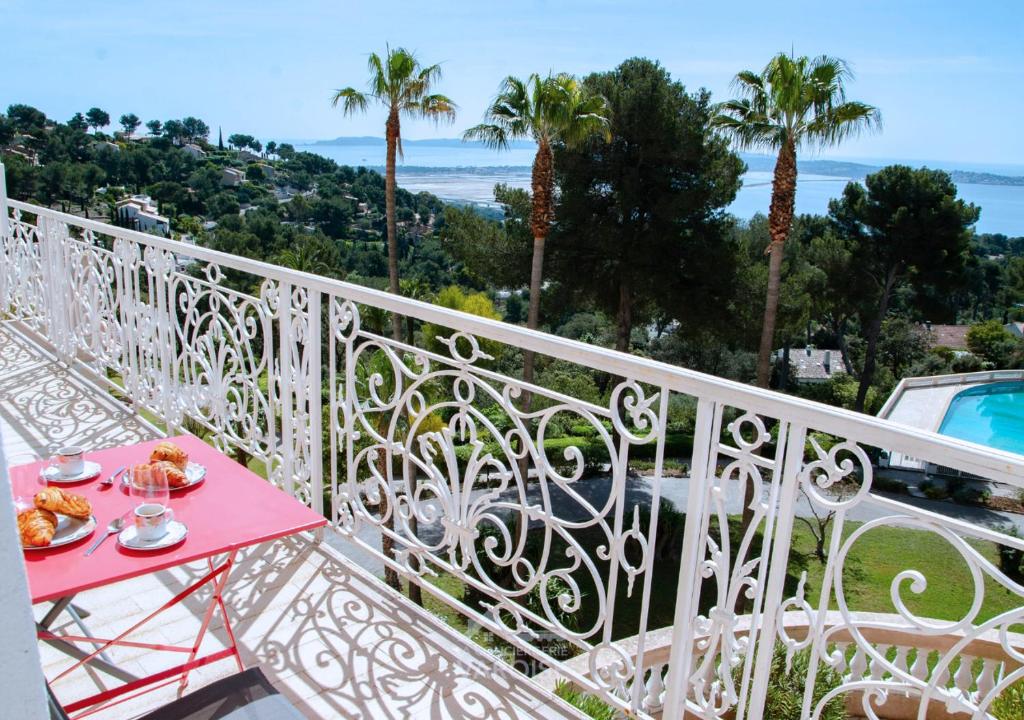 un balcon blanc avec une table avec de la nourriture dessus dans l'établissement Grand Standing Hyères T3 - Vue mer - Piscine - Tennis, à Hyères