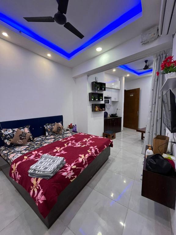 a bedroom with a bed and a ceiling with blue lights at Estates Model in Greater Noida