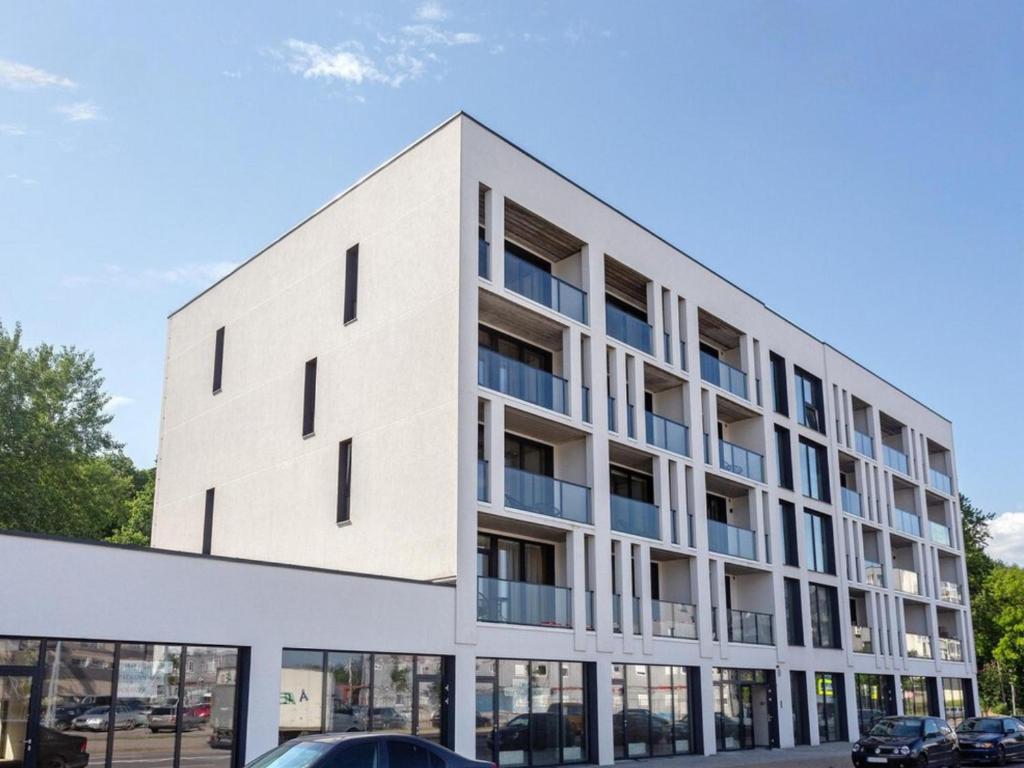 an exterior view of a white building with windows at J. Ralio apartamentai (monkey) in Vilnius