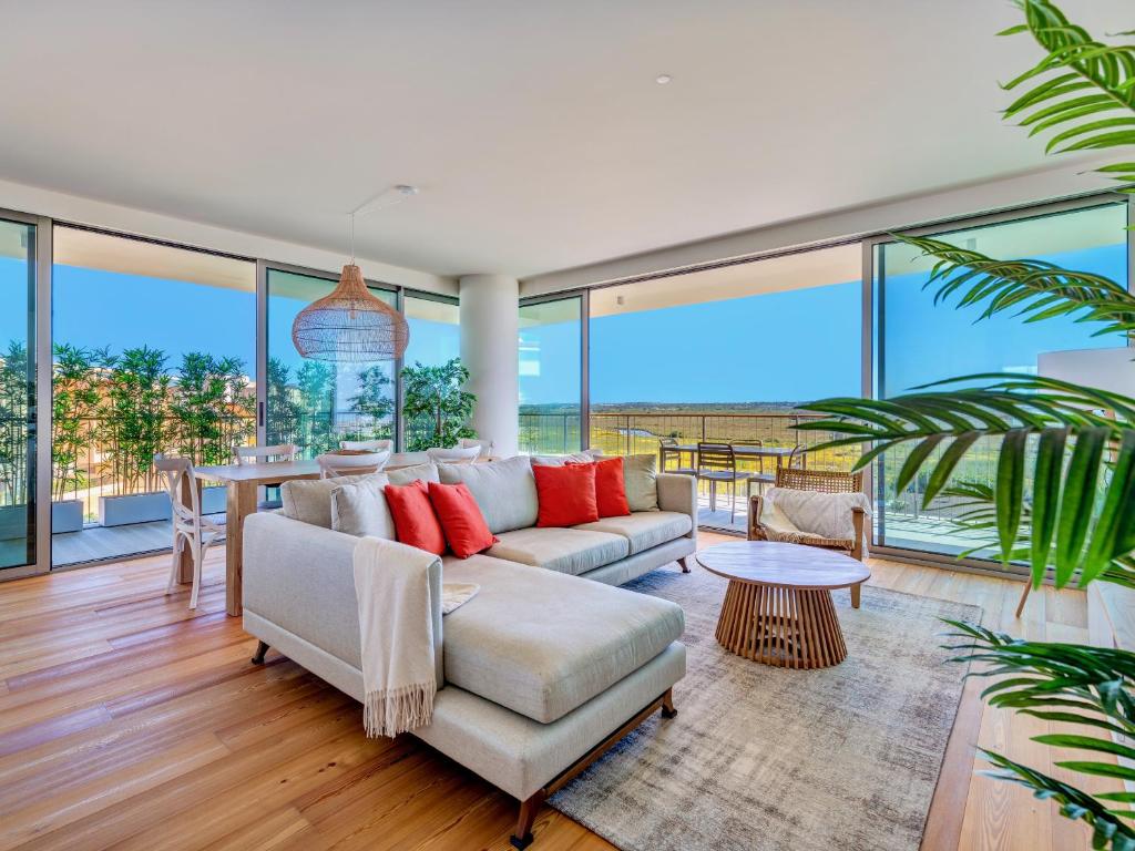 una sala de estar con un sofá y una mesa en Bayline - Beachfront Bliss & Spa by Bedzy, en Armação de Pêra