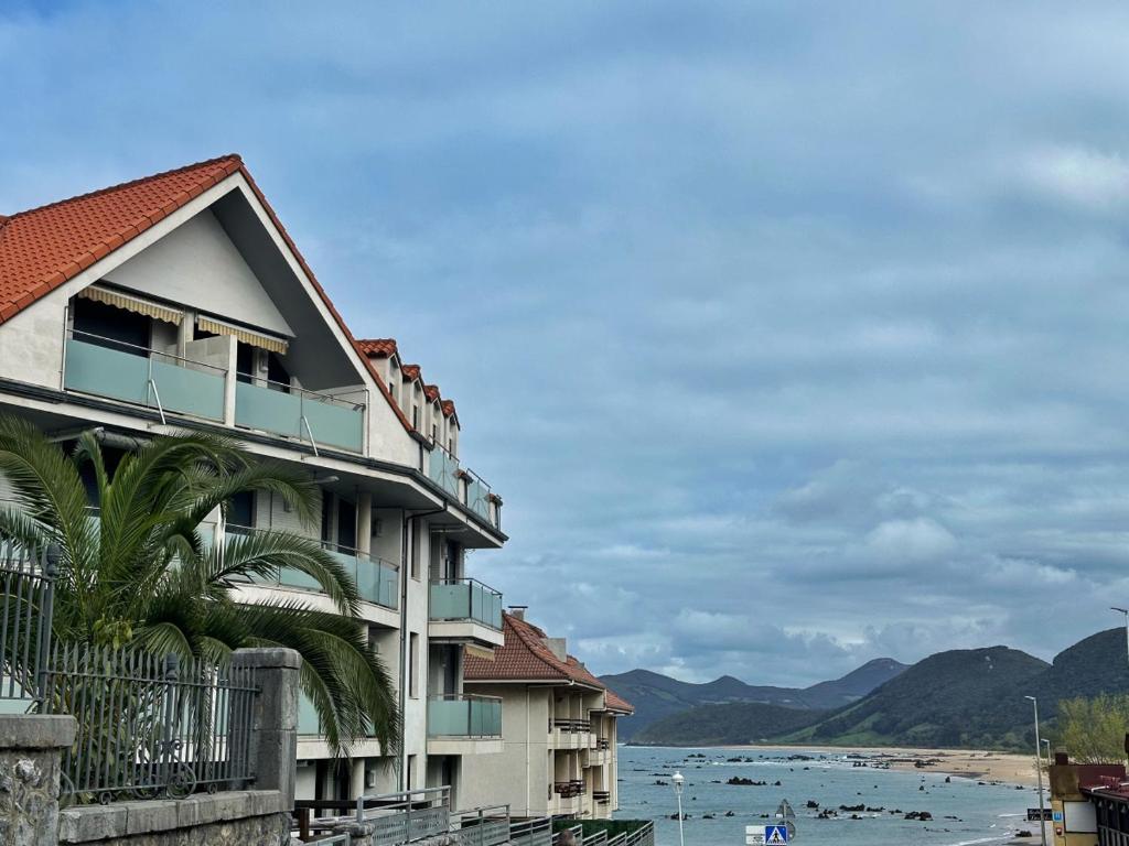 a building next to a beach with a body of water at El Patuco - 6821 in Noja