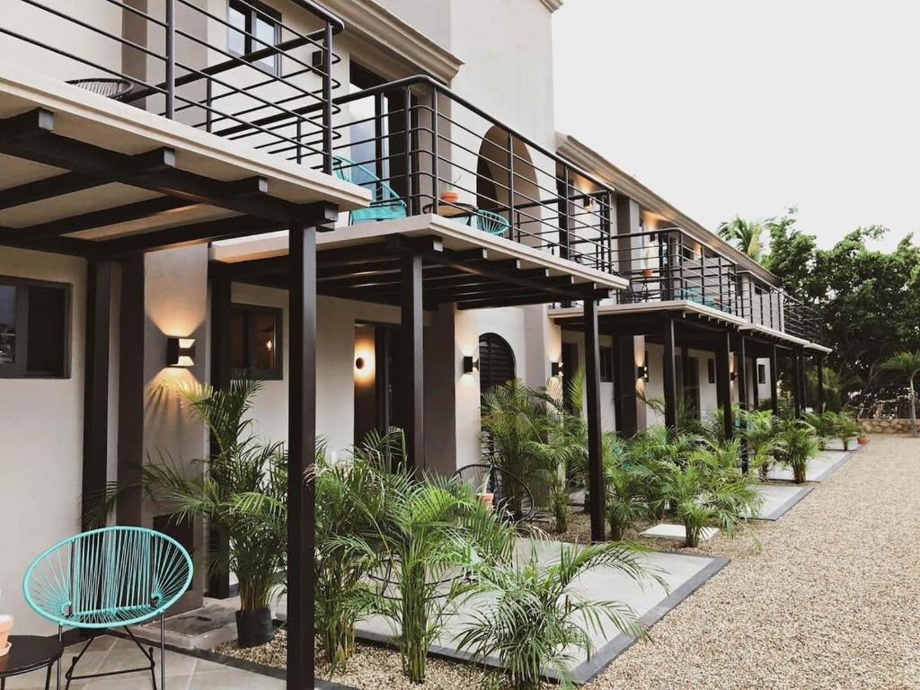 un edificio con balcón, sillas y plantas en 4 Charming Suite King Rooms in Luxurious Boutique Hotel, en San José del Cabo