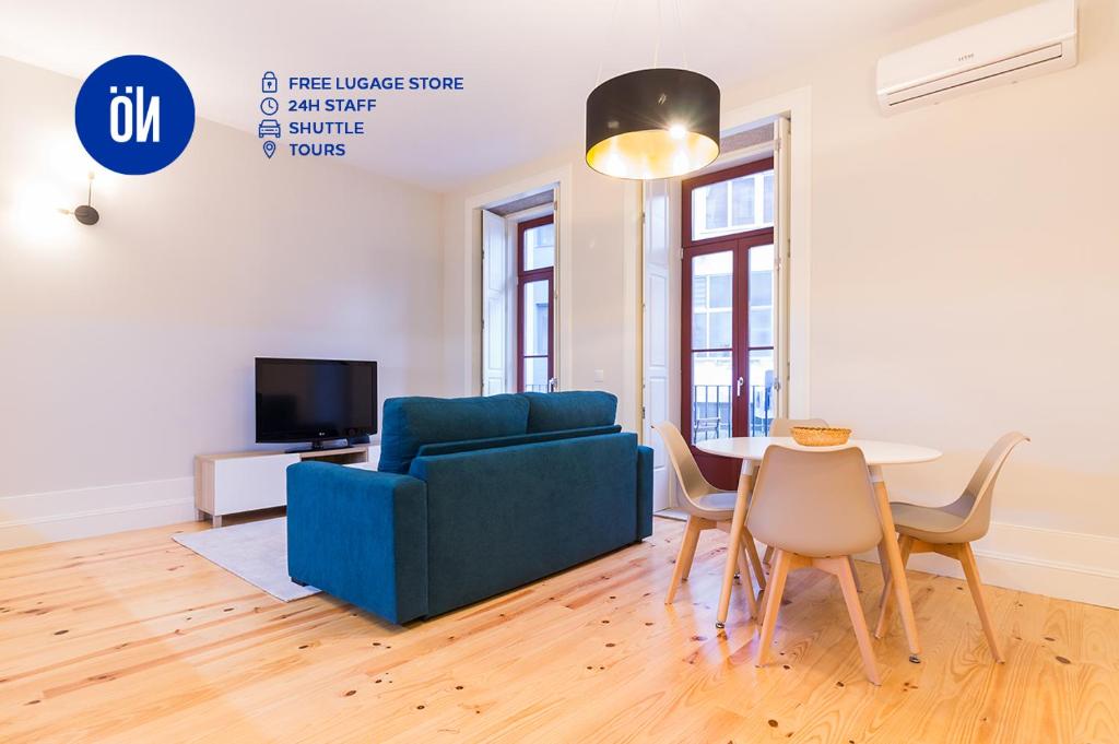 ein Wohnzimmer mit einem blauen Sofa und einem Tisch in der Unterkunft Oporto Near Coliseu in Porto