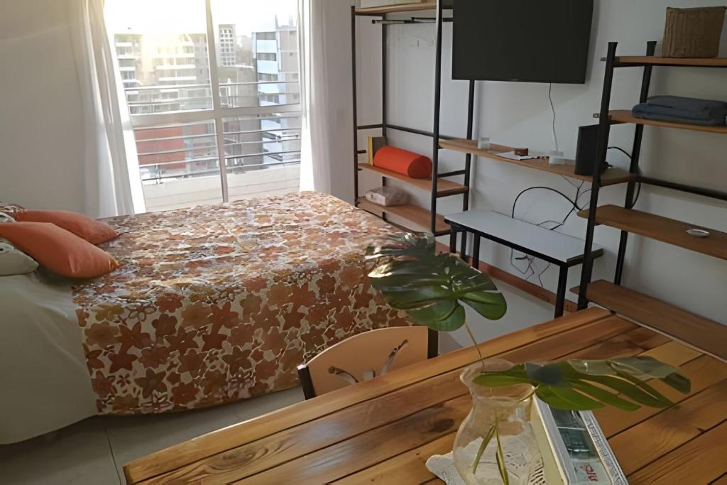 a bedroom with a bed and a table and a window at Hornera Lagos - Moderno, amplio y luminoso in Rosario